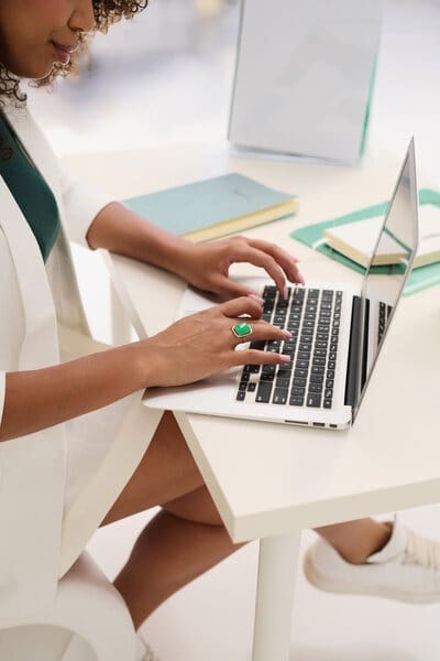 Women is typing on a laptop and learning the 10 signs she is in a recalibration season of her business