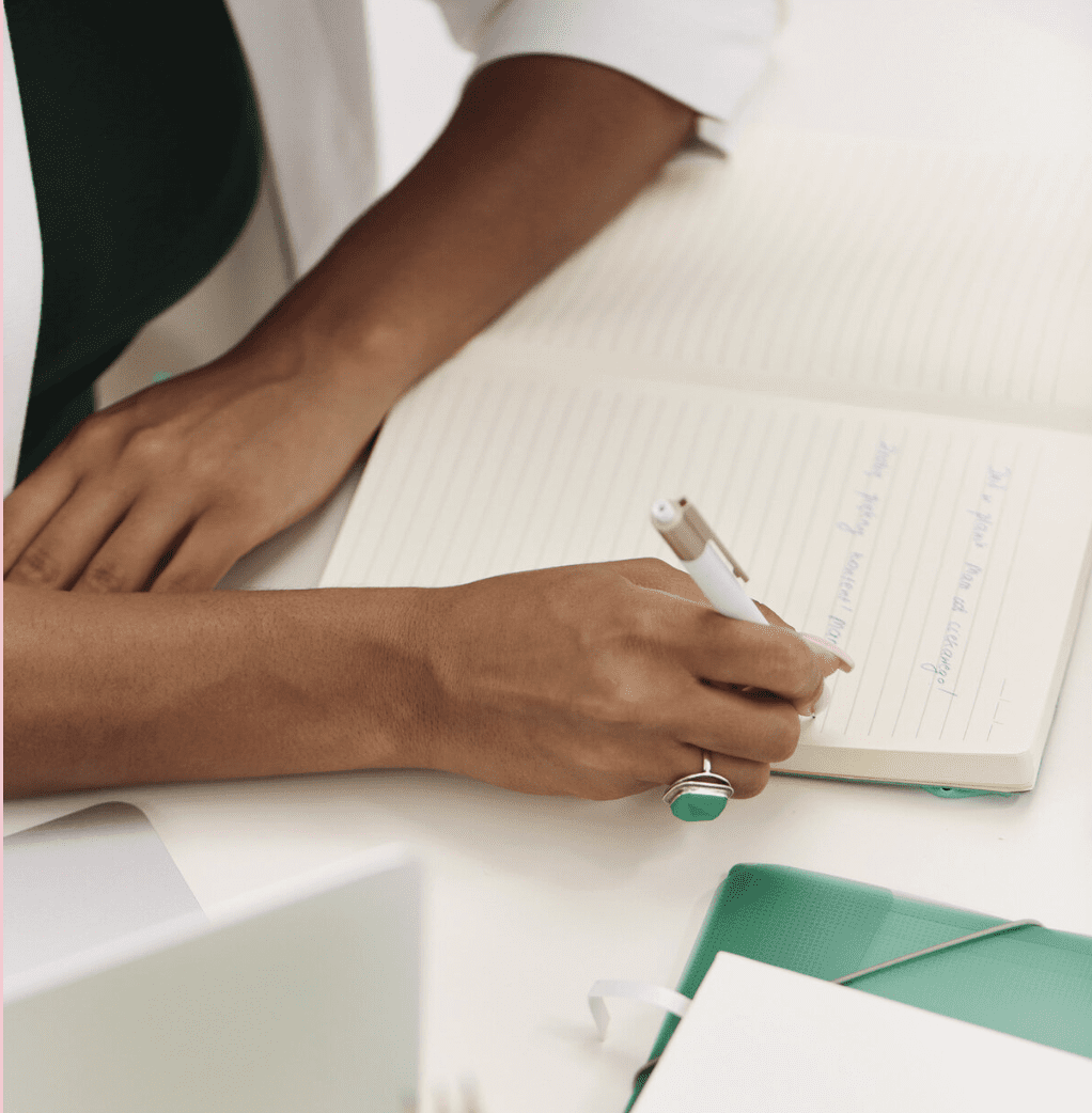 Woman writes on a paper discussing the four business seasons.